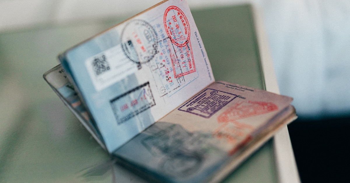 Зарубежная банковская карта Visa на ноутбуке с открытой страницей бронирования отеля рядом с паспортом — оплата Booking и Airbnb для россиянина