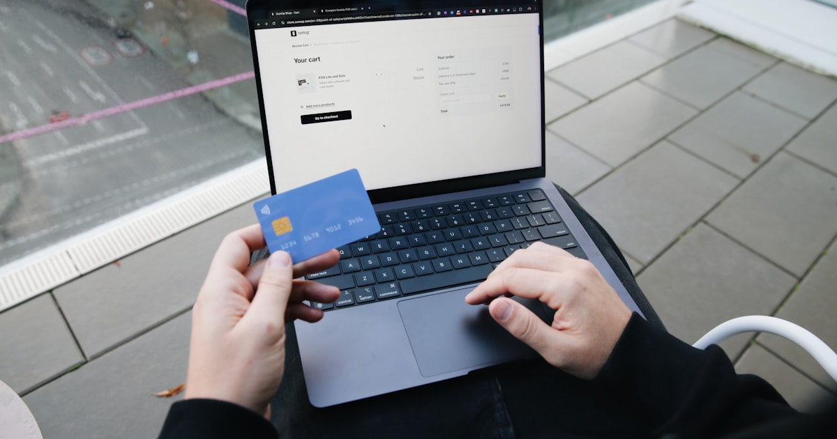 Человек делает онлайн-перевод на ноутбуке и смартфоне — переводы card-to-card, СБП и криптовалюта